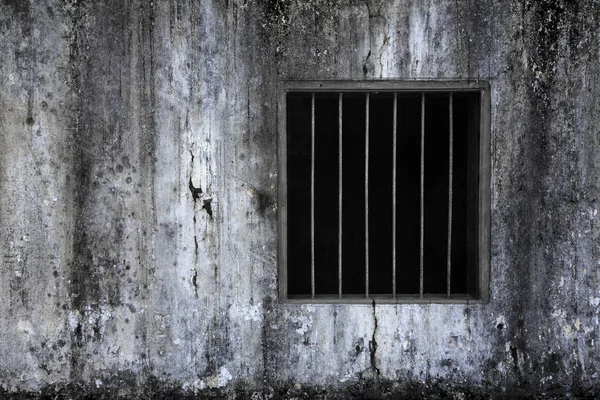 Window with rusty bars on old grungy prison cell wall Stock Picture