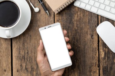 Ahşap masa üstü görünümünde boş ekran akıllı telefon ve bilgisayar.