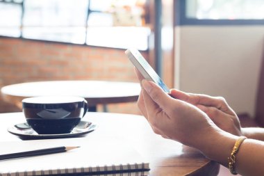 bir telefon kullanarak el kadın, ahşap masada boş ekran akıllı telefon Kafede 