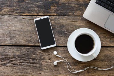 ahşap masa üstü görünümünde kahve fincanı ve bilgisayar ile akıllı telefon kapatın., kırpma yolu ile