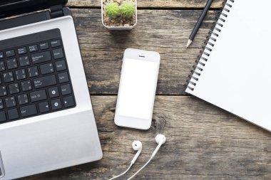 ahşap masa üstü görünümünde akıllı telefon ve bilgisayar.