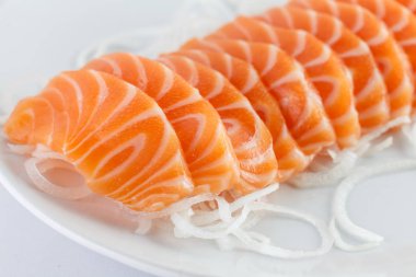 Somon balığı, beyaz arka planda bir tabakta çiğ.