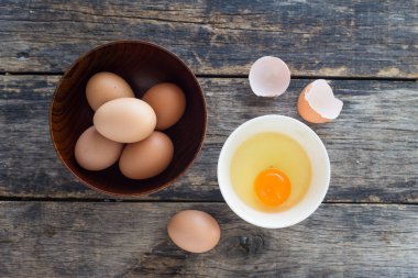 Tahta bir kasede yumurtalar Eski ahşap masa manzarasında