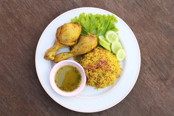 Arroz amarillo musulmán con pollo en un plato blanco sobre una madera — Foto de Stock