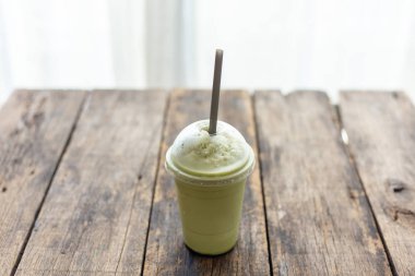 Ahşap masada cam yeşil çay smoothies