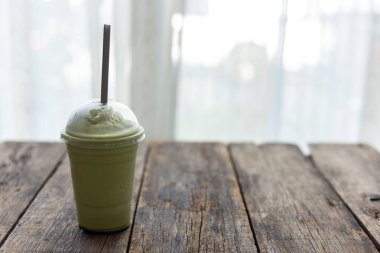 Ahşap masada cam yeşil çay smoothies