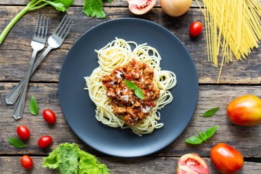 Tahta arka planda siyah tabakta spagetti. en üstteki görünüm