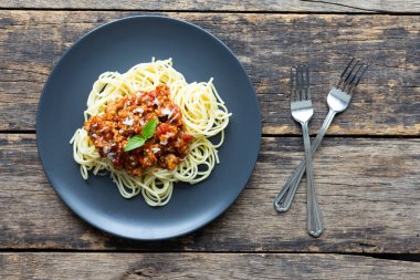 Tahta arka planda siyah tabakta spagetti. en üstteki görünüm