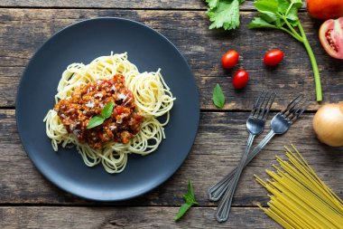 Tahta arka planda siyah tabakta spagetti. en üstteki görünüm