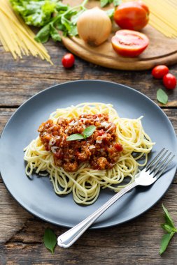 Tahta arka planda siyah tabakta spagetti. en üstteki görünüm