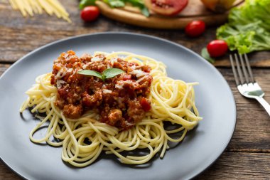 Tahta arka planda siyah tabakta spagetti. en üstteki görünüm