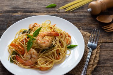 Ahşap bir masada baharatlı kızarmış karides ile Spagetti