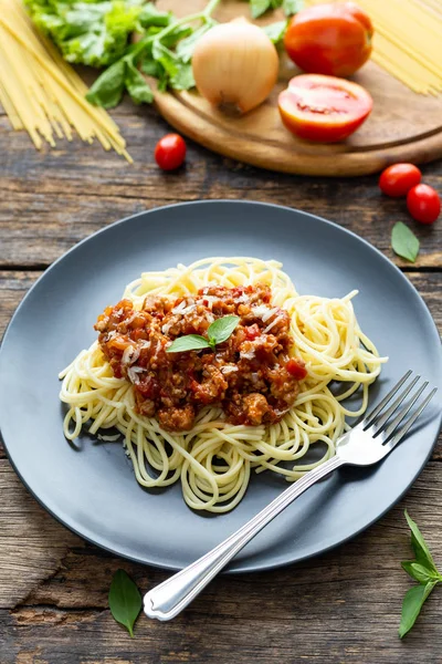 Tahta arka planda siyah tabakta spagetti. en üstteki görünüm