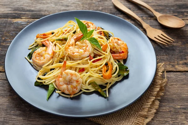 Tahta arka planda siyah tabakta spagetti. en üstteki görünüm