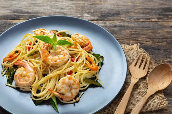 Tahta arka planda siyah tabakta spagetti. en üstteki görünüm