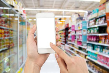 süpermarket bulanıklık arka plan üzerinde akıllı telefon kullanarak kadın el