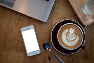 Boş ekran akıllı telefon ve bilgisayar ahşap masa üst görünümü Kahve dükkanında kırpma yolu ile