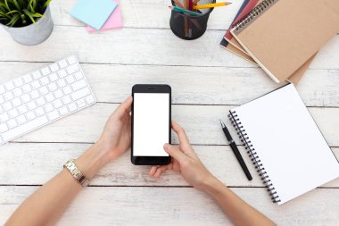 el kadını telefon kullanıyor, boş ekran akıllı telefon ve bilgisayar ahşap masa üzerinde ofis. kırpma yolu ile