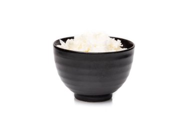 Yakın plan, siyah kasedeki pirinç beyaz arka planda izole edilmiş.