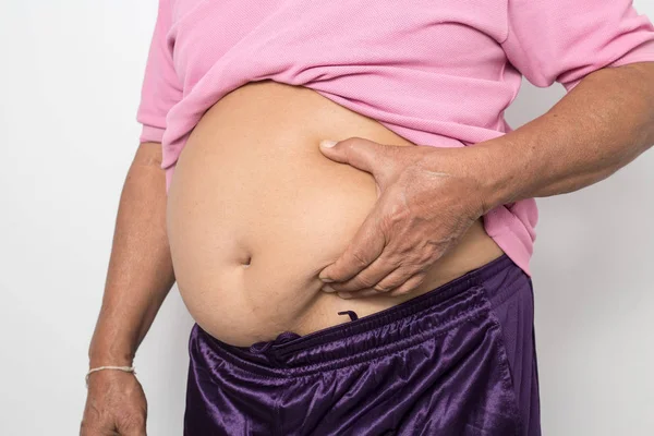Overweight man hand pinching excessive belly fat on white backgr