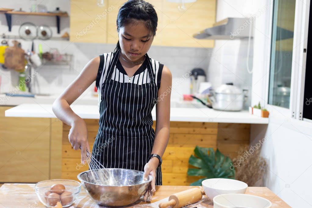 Girls mixing dough, making cookies in the kitchen