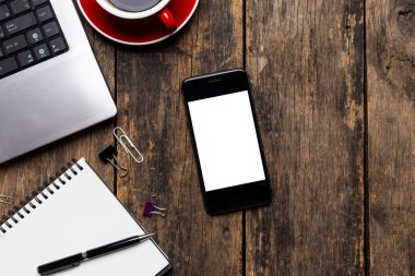 Boş ekran akıllı telefon ve bilgisayar ahşap masa manzarasında. kırpma yolu ile