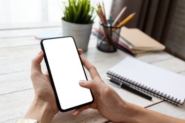 el kadını telefon kullanıyor, boş ekran akıllı telefon ve bilgisayar ahşap masa üzerinde ofis. kırpma yolu ile