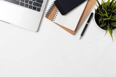Not defteri bilgisayarı ve ofis malzemeleriyle beyaz arka planda en iyi ofis masası.