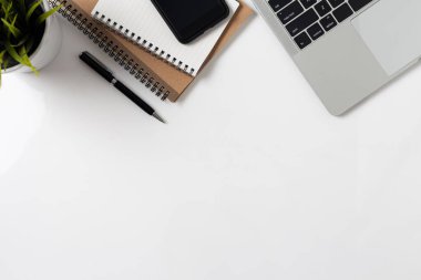 Not defteri bilgisayarı ve ofis malzemeleriyle beyaz arka planda en iyi ofis masası.