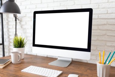 Tahta masadaki boş ekran bilgisayarı gibi. masaüstü boş beyaz ekran, çalışma alanı ve ofis malzemeleriyle