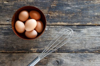 Tahta bir kasede yumurtalar Eski ahşap masa manzarasında