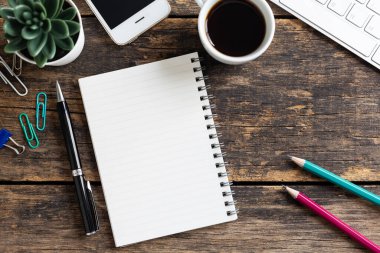 Ahşap masa üzerinde kahve ve bilgisayar olan boş defter, üst görünüm