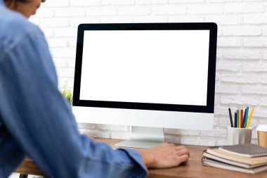 Evdeki ahşap masadaki boş ekran bilgisayarda çalışan adam.