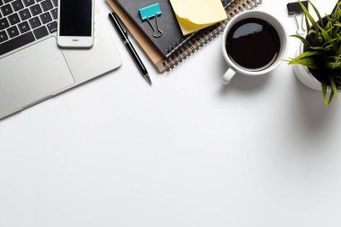 Not defteri bilgisayarı ve ofis malzemeleri beyaz arka planda olan üst görünüm çalışma alanı ofis masası