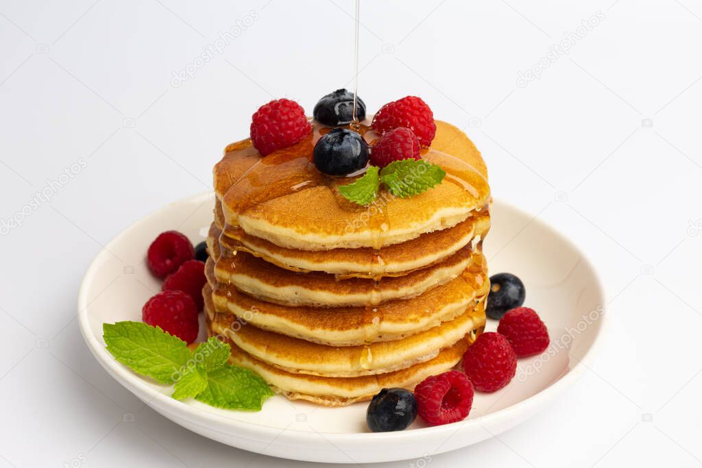 Delicious pancakes with raspberry and blueberry on White background