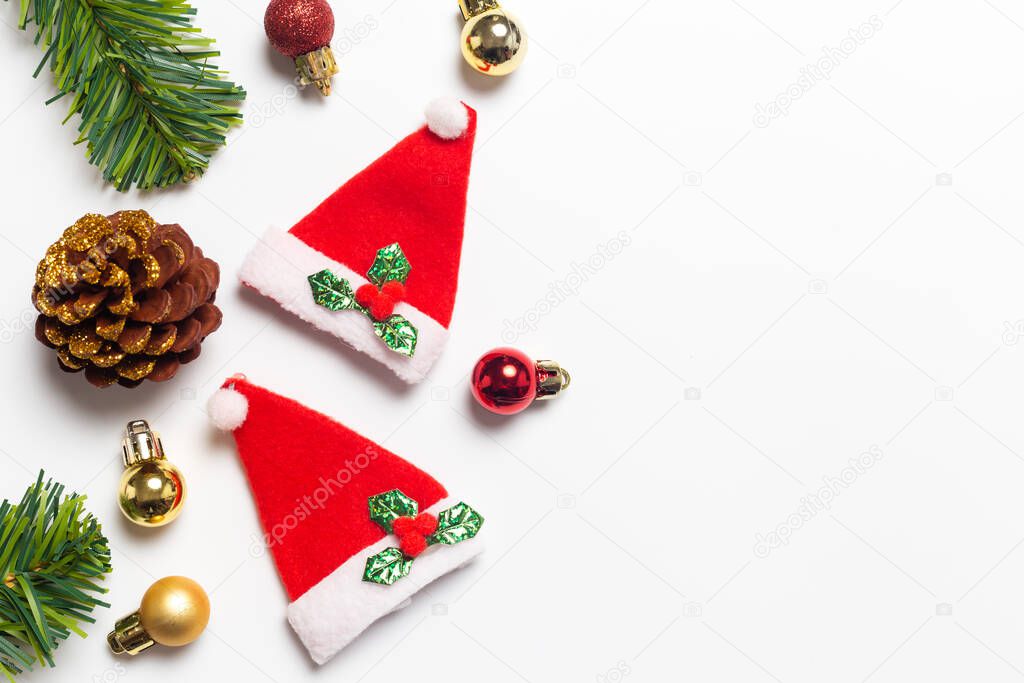Top view Christmas composition. Gifts, Pine cones and Christmas Santa Claus Hats red decorations on white background. Happy new year concept.