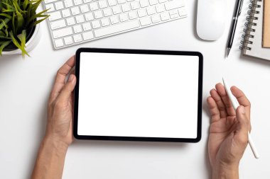 Top View Hand 'in beyaz ofis masasında boş ekranı olan tableti tutan adamı.