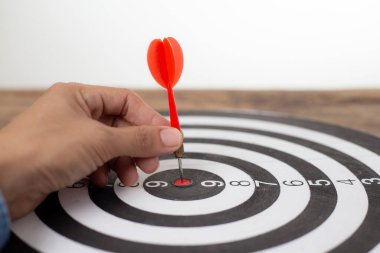 Dart tahtası hedefine doğru ok tutan el işadamı, başarılı iş konsepti
