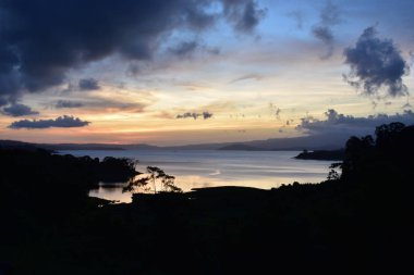 Arenal Gölü üzerinde mavi ve mor tonlarda gün batımı.