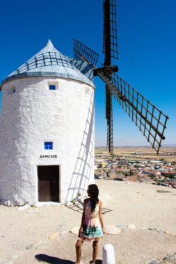 Siyah beyaz yel değirmeni ve kısa elbiseli esmer bir kız.
