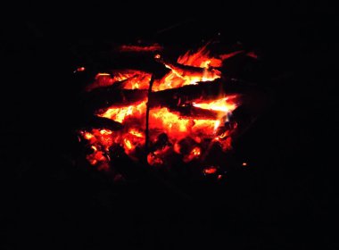 Siyah arka planda yanan bir şenlik ateşinin közleri