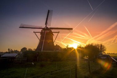 Yel değirmeni önünde güzel gün batımı, Hollanda