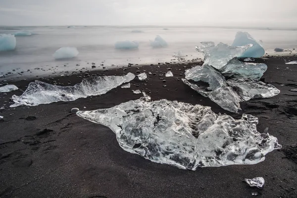 Ice krze na czarnym piasku Islandii plaży. Jokursarlon, Diamond Beach, Islandia — Zdjęcie stockowe