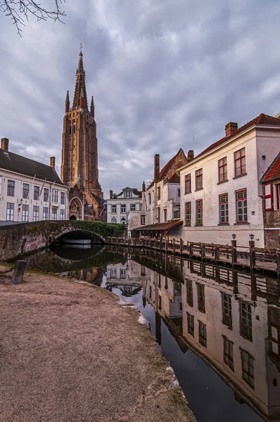 Вулиця Брюгге і Церква Богоматері відбилися у воді. Брюгге, Бельгія — стокове фото
