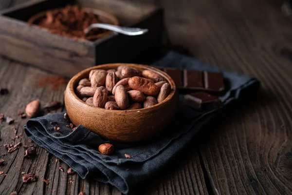 Zdravé občerstvení, superpotravinářské nepražené kakaové boby v dřevěné misce — Stock fotografie