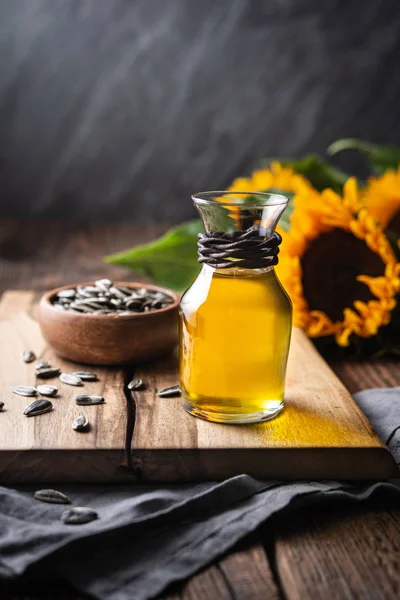 Sunflower oil in a glass jar, decorated with whole seeds and flowers — Stock Photo, Image