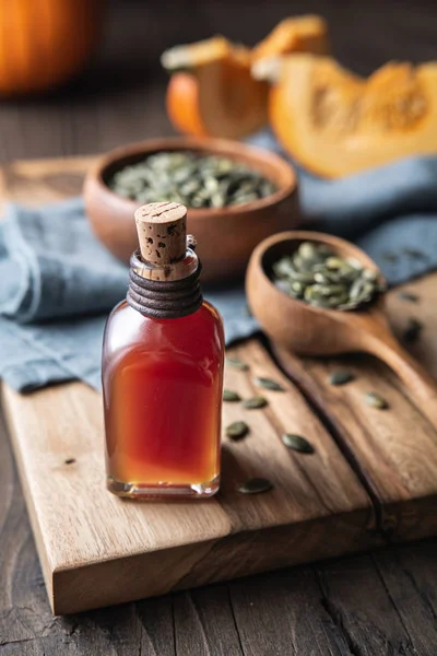 Cold pressed Pumpkin seed oil in a glass bottle, decorated with peeled seeds — Stock Photo, Image