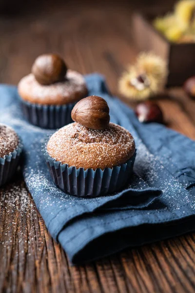 Muffins made from sweet chestnut puree and cocoa, topped with peeled and baked chestnut, dusted with powdered sugar