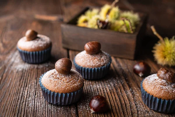 Muffins made from sweet chestnut puree and cocoa, topped with peeled and baked chestnut, dusted with powdered sugar