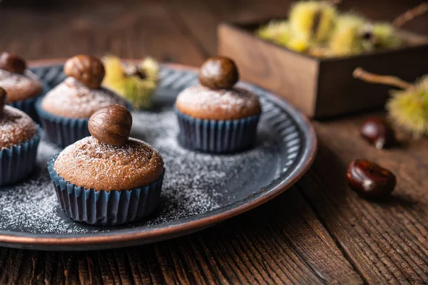 Muffins made from sweet chestnut puree and cocoa, topped with peeled and baked chestnut, dusted with powdered sugar